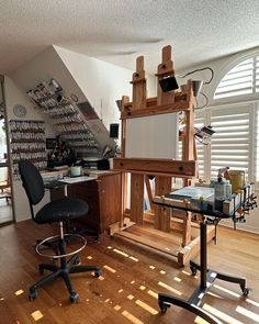 an artist's easel in the middle of a room with chairs and desks