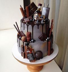 a three tiered cake with chocolate icing and assorted items