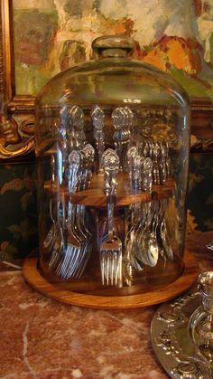 a glass jar with forks and spoons in it