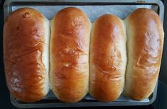 four loaves of bread sitting on top of a pan