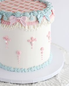 a white cake with pink and blue decorations