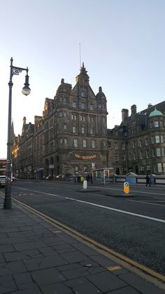 an old building on the corner of a street in front of a light pole and lamp post