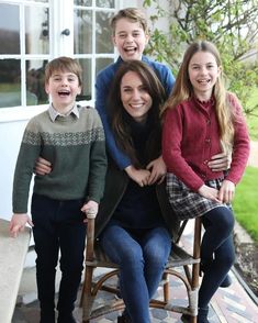 a group of people sitting on top of a wooden chair