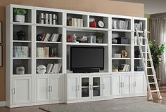 a white entertainment center with bookshelves and ladder