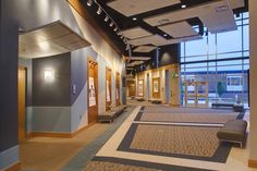 an empty lobby with large windows and carpeted flooring on both sides of the room