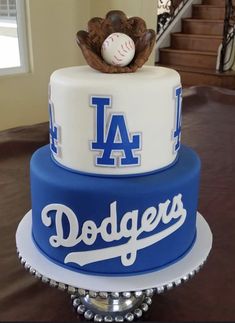 a three tiered dodgers cake with a baseball on top