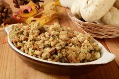 two bowls filled with cranberry stuffing on top of a wooden table next to autumn leaves