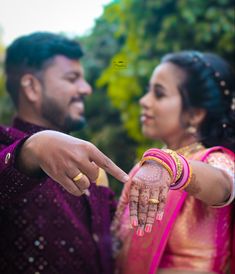 a man and woman pointing at each other with their hands on the bride's finger