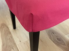 a close up of a pink chair on a wooden floor