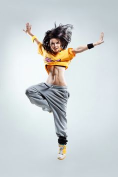 a woman is jumping in the air with her arms outstretched and legs spread wide open