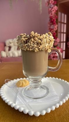 a cup filled with chocolate and nuts on top of a white plate