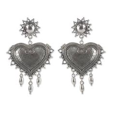 Sterling silver hearts glow with classic Mexican artistry in earrings designed by Gianluca Anzani. Shiny suns crown the earrings hiding the posts while three luminous beads gracefully cascade at the end. The earrings from Taxco are masterfully crafted by hand featuring intriguing textures and low relief details. .925 Sterling silver Heart Chandelier, Mexico Day Of The Dead, Sterling Silver Heart Earrings, Modern Mexican, Earrings Chandelier, Silver Heart Earrings, Onyx Earrings, Sterling Silver Hoop Earrings, Handcrafted Earrings