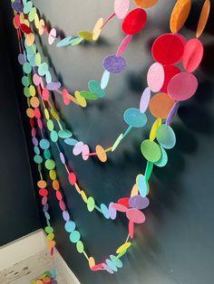 colorful paper garland hanging from the side of a wall