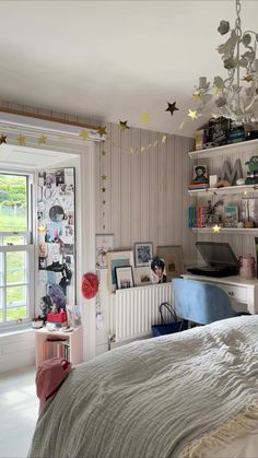 a bedroom with a bed, desk and shelves on the wall next to a window