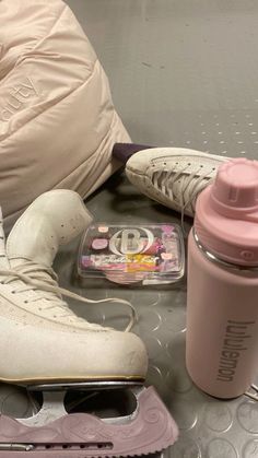 a pair of shoes, water bottle and cell phone sitting on a table with other items