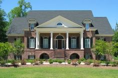 a large brick house with columns and windows