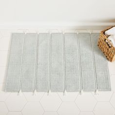 a bathroom rug on the floor next to a basket