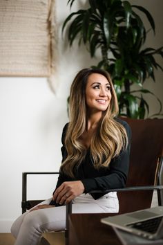 a woman sitting in a chair smiling at the camera