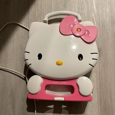 a hello kitty cell phone case with a pink bow on the front and white handles