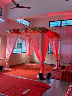 a room decorated with red drapes and flowers