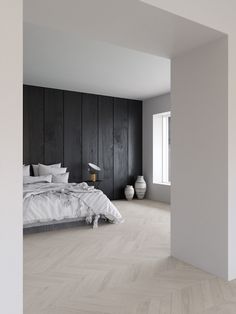 an empty bedroom with wood paneled walls and white bedding in the foreground