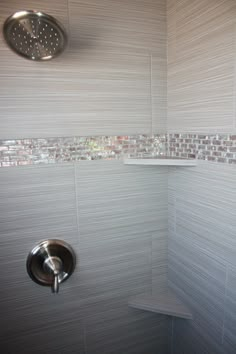 the shower head is mounted to the side of the wall and it has a tile pattern