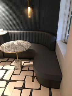 a black and white tiled floor with a round table in the corner next to it