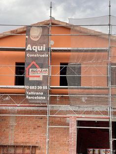 a building under construction with scaffolding around it and a sign on the side