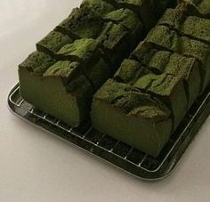 there are many pieces of green cake on the tray