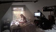 a dog sitting on top of a bed next to a tv set in a room