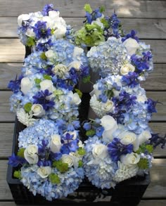 blue and white flowers are arranged in a wreath