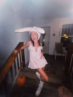 a girl in bunny ears is standing on the stairs