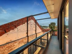 a balcony with brick walls and glass railings