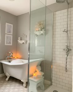 a white bath tub sitting next to a walk in shower under a bathroom light fixture