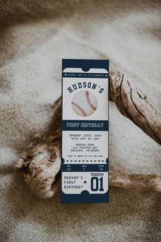 a baseball ticket sitting on top of a bed next to a piece of driftwood