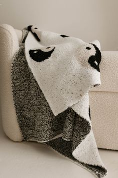 a white and black blanket sitting on top of a couch