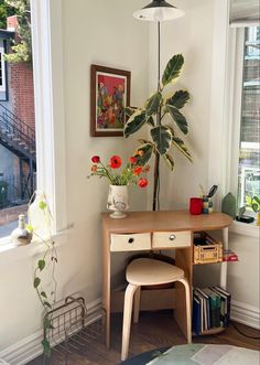 a room with a desk, chair and potted plant