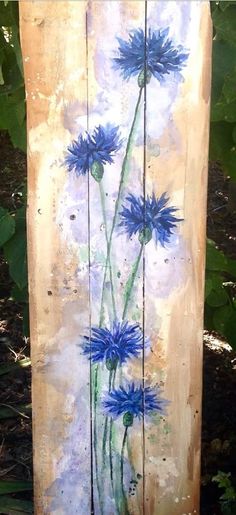 a wooden sign with blue flowers painted on it