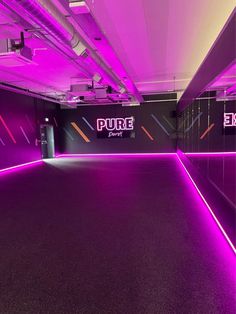 an empty room with purple lighting in the center and black walls on both sides that says pure energy