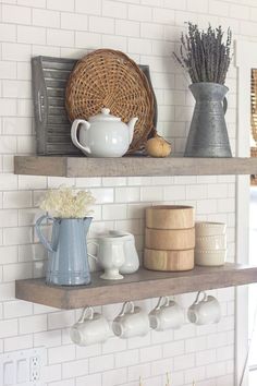 two shelves with cups, mugs and other items on them in a white kitchen