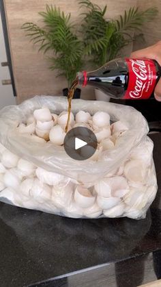 a person pouring coke into a bag filled with marshmallows