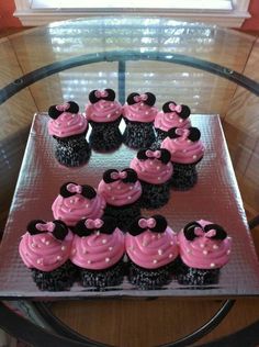 cupcakes with pink frosting and minnie mouse ears on top are arranged in the shape of a heart