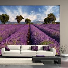 a living room with a couch and wall mural in front of the lavender field that looks like it is going to bloom