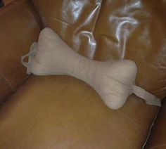 a white dog bone laying on top of a brown leather couch