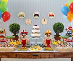 a table topped with cakes and desserts next to balloons