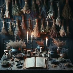 an open book sitting on top of a wooden table next to candles and other items