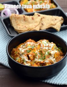 paneer tawa masala in a black bowl with pita bread on the side