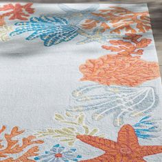 an orange and blue rug with starfishs, corals and other sea creatures on it