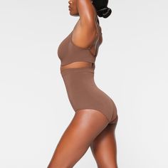 Shape your curves and feel supported in this stretchy shapewear high waisted brief with strong targeted compression at the tummy and waist, butt-shaping pockets, and a silicone interior underband that keeps it from rolling down. Hits right below the bust and features a wider crotch for added coverage and a cotton gusset. Fits true to size. | SKIMS High-Waisted Brief | Medium Neutral | Seamless Sculpt High Waisted Briefs, Shapewear, Lounge Wear, High Waisted