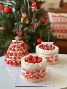 three small cakes sitting on top of a table next to a christmas tree